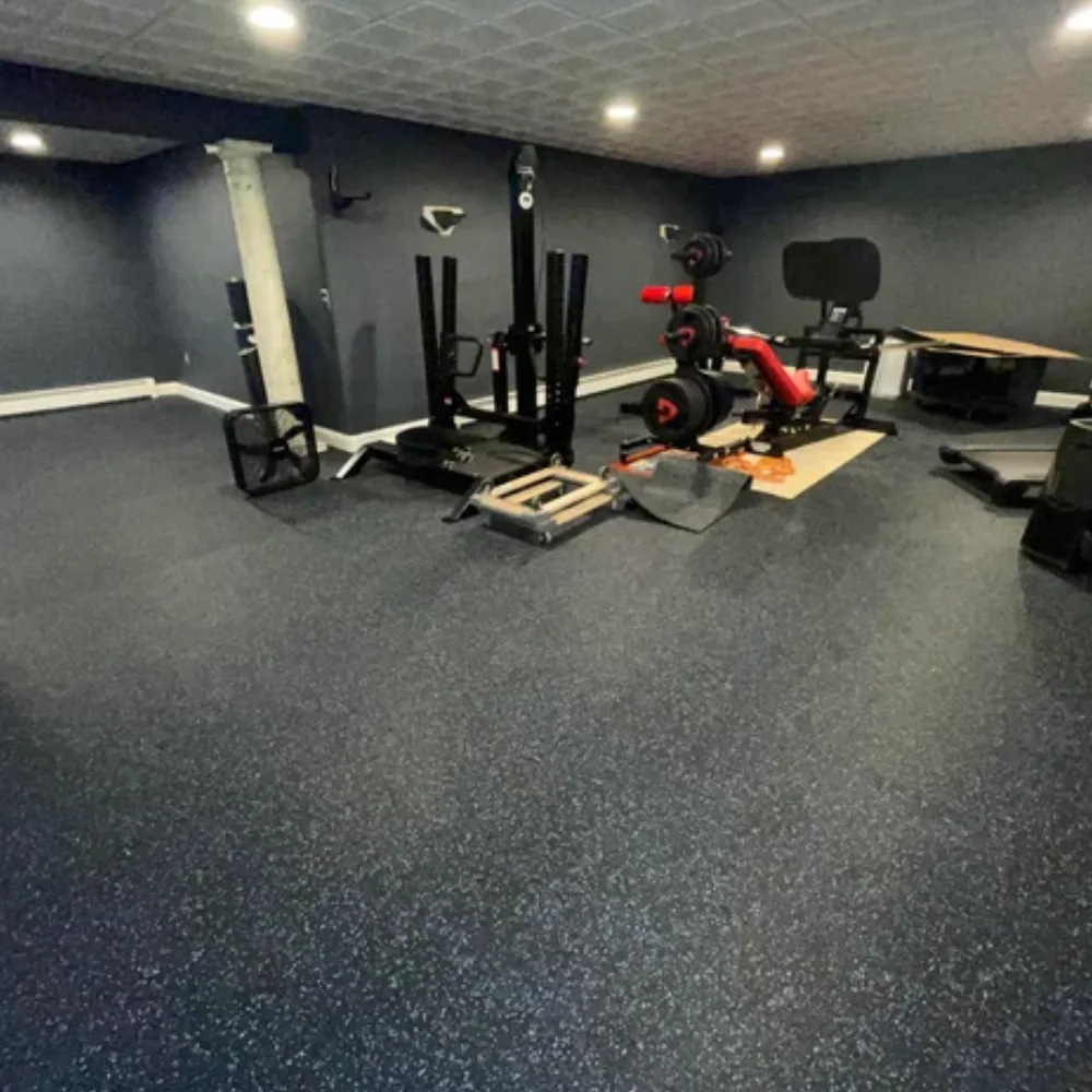 Durable black speckled Gym Flooring installed in a home workout room with exercise gear.