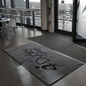 High-definition printed Logo Mats on a sleek grey lobby floor for a professional look.