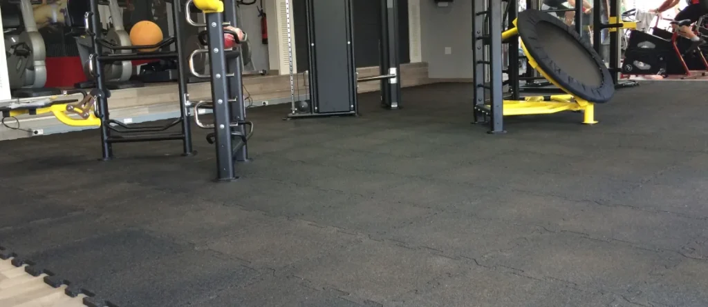 Dense rubber gym mats installed under weightlifting equipment